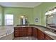 Bathroom featuring a dual sink vanity with granite countertops, dark cabinets, and a soaking tub at 604 Timberwilde Ct, Winter Springs, FL 32708