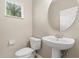 Powder room featuring modern toilet and round mirror at 6874 Slaven Dr, Orlando, FL 32819
