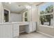 Bright bathroom with double vanity, white cabinets, large mirror, tile floor, and natural light at 6874 Slaven Dr, Orlando, FL 32819