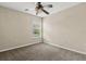 A cozy bedroom with neutral carpet, ceiling fan, and a window offering natural light at 6874 Slaven Dr, Orlando, FL 32819