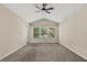 A spacious bedroom with neutral carpet, ceiling fan, and three windows offering natural light at 6874 Slaven Dr, Orlando, FL 32819