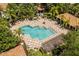 Aerial view of a community pool featuring lounge chairs and umbrellas surrounded by lush tropical landscaping at 6874 Slaven Dr, Orlando, FL 32819