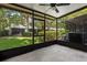 A screened-in porch with a ceiling fan provides a relaxing outdoor living space with views of the backyard at 6874 Slaven Dr, Orlando, FL 32819