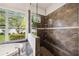 Bathroom showing the walk-in shower with a built-in seat and a large window for ample natural light at 748 Mills Estate Pl, Chuluota, FL 32766