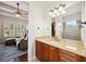 Bathroom vanity with granite countertop and view into the Gathering room with abundant sunlight at 748 Mills Estate Pl, Chuluota, FL 32766