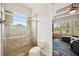 Bathroom with glass-enclosed shower featuring tile, a window, and view into the Gathering room at 748 Mills Estate Pl, Chuluota, FL 32766