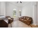 Sitting room with tile floors, leather sofa and arm chair, desk and sun-filled arched windows at 748 Mills Estate Pl, Chuluota, FL 32766