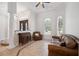 Sitting room with tile floors, leather sofa and arm chair, desk and sun-filled arched windows at 748 Mills Estate Pl, Chuluota, FL 32766