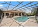 Enclosed pool with a jacuzzi, lounge chairs, an outdoor dining area, and a well-maintained surrounding landscape at 748 Mills Estate Pl, Chuluota, FL 32766