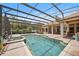 Relaxing in-ground swimming pool with a screened enclosure, connected jacuzzi, and a spacious patio area at 748 Mills Estate Pl, Chuluota, FL 32766
