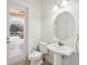 Bright powder room with pedestal sink and a view of the outdoor patio at 748 Mills Estate Pl, Chuluota, FL 32766