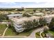 An aerial view of the three-story condominium building surrounded by green trees and golf courses at 7509 Mourning Dove Cir # 204, Reunion, FL 34747