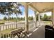 Spacious covered balcony with ceiling fan featuring a small table and comfortable outdoor seating with park views at 7509 Mourning Dove Cir # 204, Reunion, FL 34747