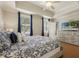Bright bedroom featuring a queen bed, ceiling fan, and dresser with television at 7509 Mourning Dove Cir # 204, Reunion, FL 34747
