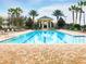 Well-maintained community pool featuring plenty of seating and a covered gazebo for a resort-like experience at 7509 Mourning Dove Cir # 204, Reunion, FL 34747