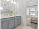 Bathroom with double vanity, large mirror and view into carpeted bedroom at 923 Colie Aly, Winter Garden, FL 34787