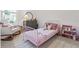 Bedroom with a pink bed, dresser and rocking chair on a neutral colored carpet at 923 Colie Aly, Winter Garden, FL 34787