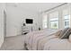 Bright bedroom with carpet, dresser with tv, and large window with natural light at 923 Colie Aly, Winter Garden, FL 34787
