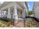 Inviting two-story home with a cozy front porch and well-manicured landscaping and black metal fence at 923 Colie Aly, Winter Garden, FL 34787