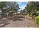 Community playground featuring multiple swings and a wood chip safety surface surrounded by mature trees at 923 Colie Aly, Winter Garden, FL 34787