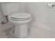 Close-up of a standard white toilet in a bathroom with neutral tile at 923 Colie Aly, Winter Garden, FL 34787