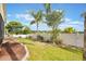 Landscaped backyard featuring a white fence, palm trees, and well-maintained lawn at 930 Willow Oak Loop, Minneola, FL 34715