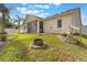 Large backyard features a fire pit, retaining wall, and tropical landscaping at 930 Willow Oak Loop, Minneola, FL 34715
