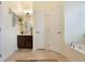 Light and bright bathroom featuring a soaking tub, vanity, and linen closet at 930 Willow Oak Loop, Minneola, FL 34715