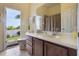 Bright bathroom featuring a large mirror, white countertops, and an open doorway to the yard at 930 Willow Oak Loop, Minneola, FL 34715