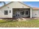 Rear exterior view showcasing the screened lanai with access to the backyard at 930 Willow Oak Loop, Minneola, FL 34715