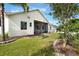 Rear view highlighting the screened lanai, complemented by lush landscaping and a manicured lawn at 930 Willow Oak Loop, Minneola, FL 34715