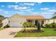 Charming single Gathering home with manicured lawn, brick driveway, and inviting covered porch at 930 Willow Oak Loop, Minneola, FL 34715