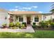 Inviting front porch with white pillars and ceiling fans, surrounded by lush landscaping at 930 Willow Oak Loop, Minneola, FL 34715