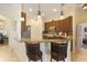 Kitchen with pendant lights, brown cabinets, stainless steel appliances, and granite countertops at 930 Willow Oak Loop, Minneola, FL 34715