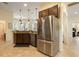 Spacious kitchen with stainless steel refrigerator, dark wood cabinetry, and open view to dining area at 930 Willow Oak Loop, Minneola, FL 34715
