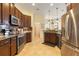 Stylish kitchen with stainless steel appliances, dark cabinets, and granite countertops at 930 Willow Oak Loop, Minneola, FL 34715