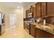 Well-lit kitchen featuring wooden cabinets, stainless steel appliances, and tile flooring at 930 Willow Oak Loop, Minneola, FL 34715