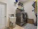 Convenient laundry room with utility sink, shelving and stainless steel washer and dryer at 930 Willow Oak Loop, Minneola, FL 34715