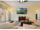 Spacious living room featuring a large TV, comfortable seating, and sliding glass doors at 930 Willow Oak Loop, Minneola, FL 34715