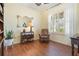 Comfortable living room with wood floors, decorative mirror, accent chair and plantation shutters at 930 Willow Oak Loop, Minneola, FL 34715