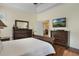 The main bedroom features wood floors, ceiling detail, and a TV at 930 Willow Oak Loop, Minneola, FL 34715