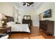 Beautiful main bedroom with dark wood bedroom furniture, wood floors, and a tray ceiling at 930 Willow Oak Loop, Minneola, FL 34715
