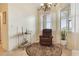 Cozy sitting area with a comfortable chair, chandelier, and natural light from the window at 930 Willow Oak Loop, Minneola, FL 34715