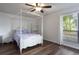 Bright bedroom with wood floors, a four-poster bed, a ceiling fan, and natural light from a window at 940 Douglas Ave # 159, Altamonte Springs, FL 32714