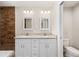 Bathroom features double sink vanity with granite counters and wood-look tiled accent wall at 1059 Ne 130Th Ter, Silver Springs, FL 34488