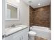 Bathroom boasts tub-shower combo, wood-look accent wall, and granite vanity at 1059 Ne 130Th Ter, Silver Springs, FL 34488