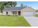 Charming single-story home featuring a two-car garage, well-maintained lawn, and neutral color palette at 1059 Ne 130Th Ter, Silver Springs, FL 34488