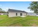 Exterior view of home's rear with sliding glass door and ample yard at 1059 Ne 130Th Ter, Silver Springs, FL 34488