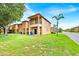 Exterior of a two-story home featuring a balcony, lawn, palm tree, and nearby road at 109 Cambria Ave, Davenport, FL 33897