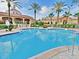 Large outdoor swimming pool surrounded by sun loungers and palm trees at clubhouse at 109 Cambria Ave, Davenport, FL 33897